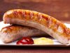 Roasted sausage with bread served on a paper tray Roasted sausage with bread served on a paper tray - wood board